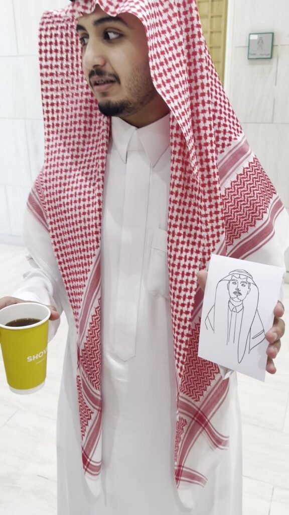 ضيف يستلم رسمته من الروبوت الرسام
